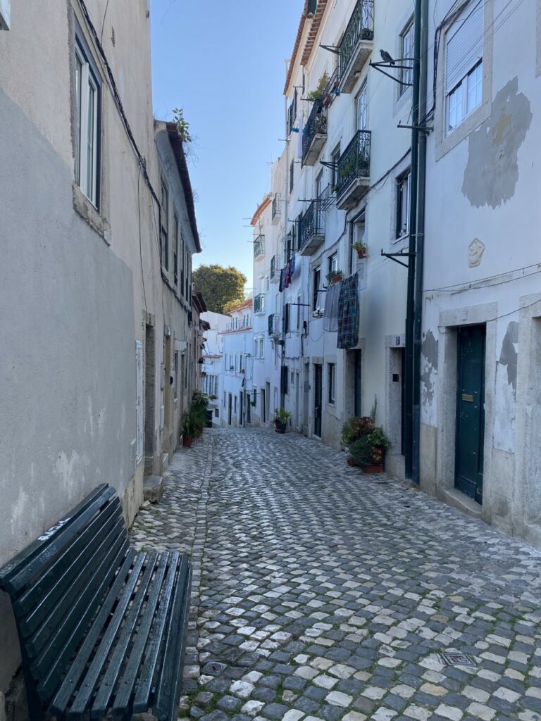 A photograph of a cobbled street in Alfama, Lisbon in Portugal