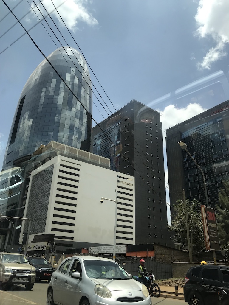 a portrait image of a skyscraper building in nairobi, taken from a car window on a mobile phone