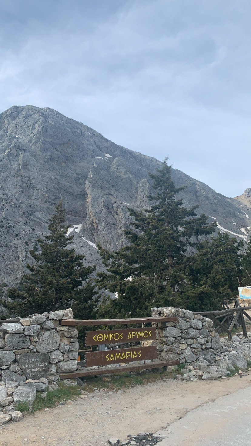 The entrance to the Samaria gorge, with a sign written in Greek in the foreground