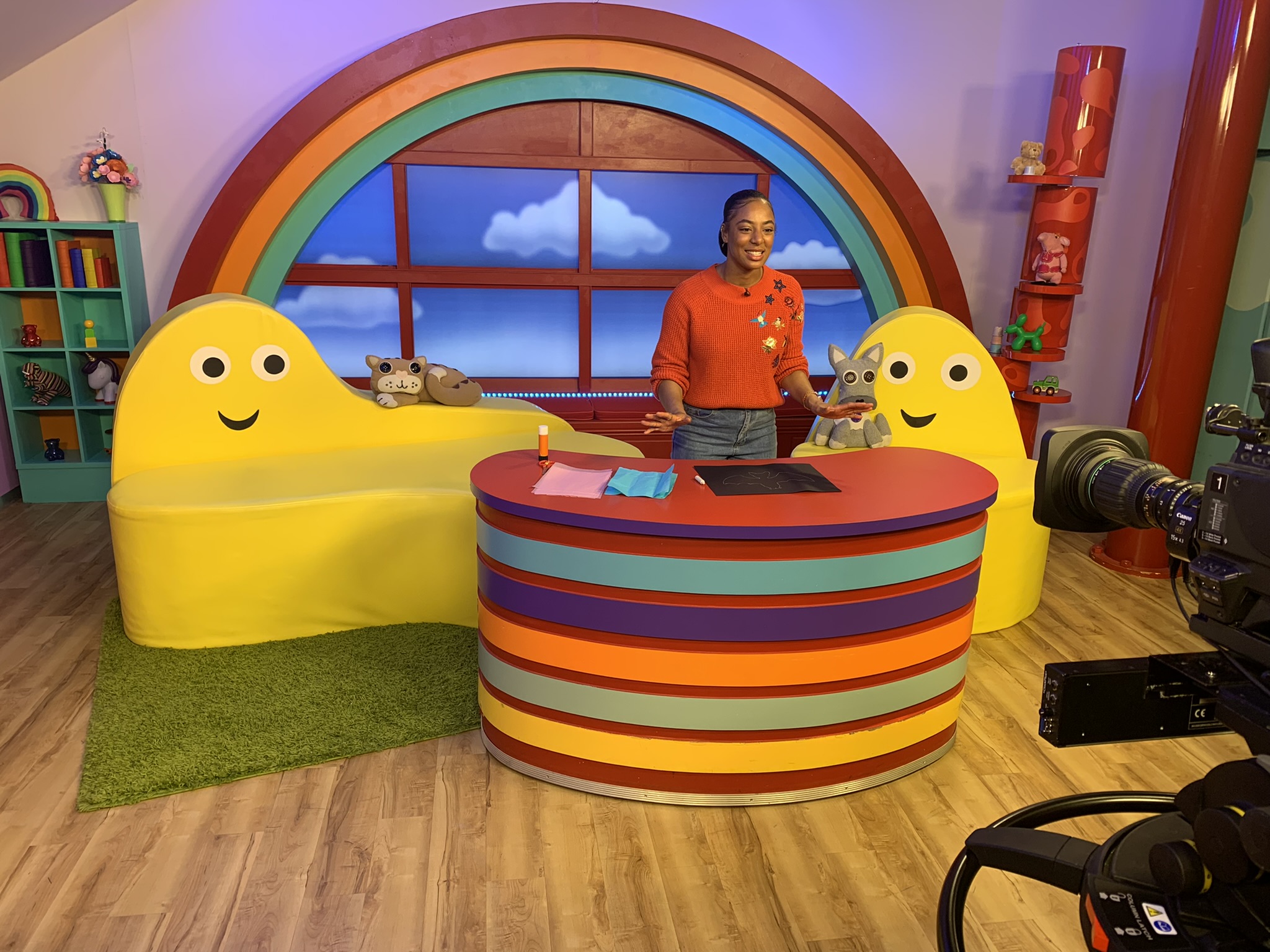 an image of Chantelle on a bright and colourful children's tv set. She is talking into the camera 