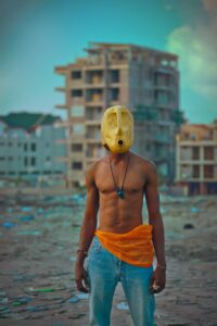 Model stands in Kinshasa wearing plastic can as mask.